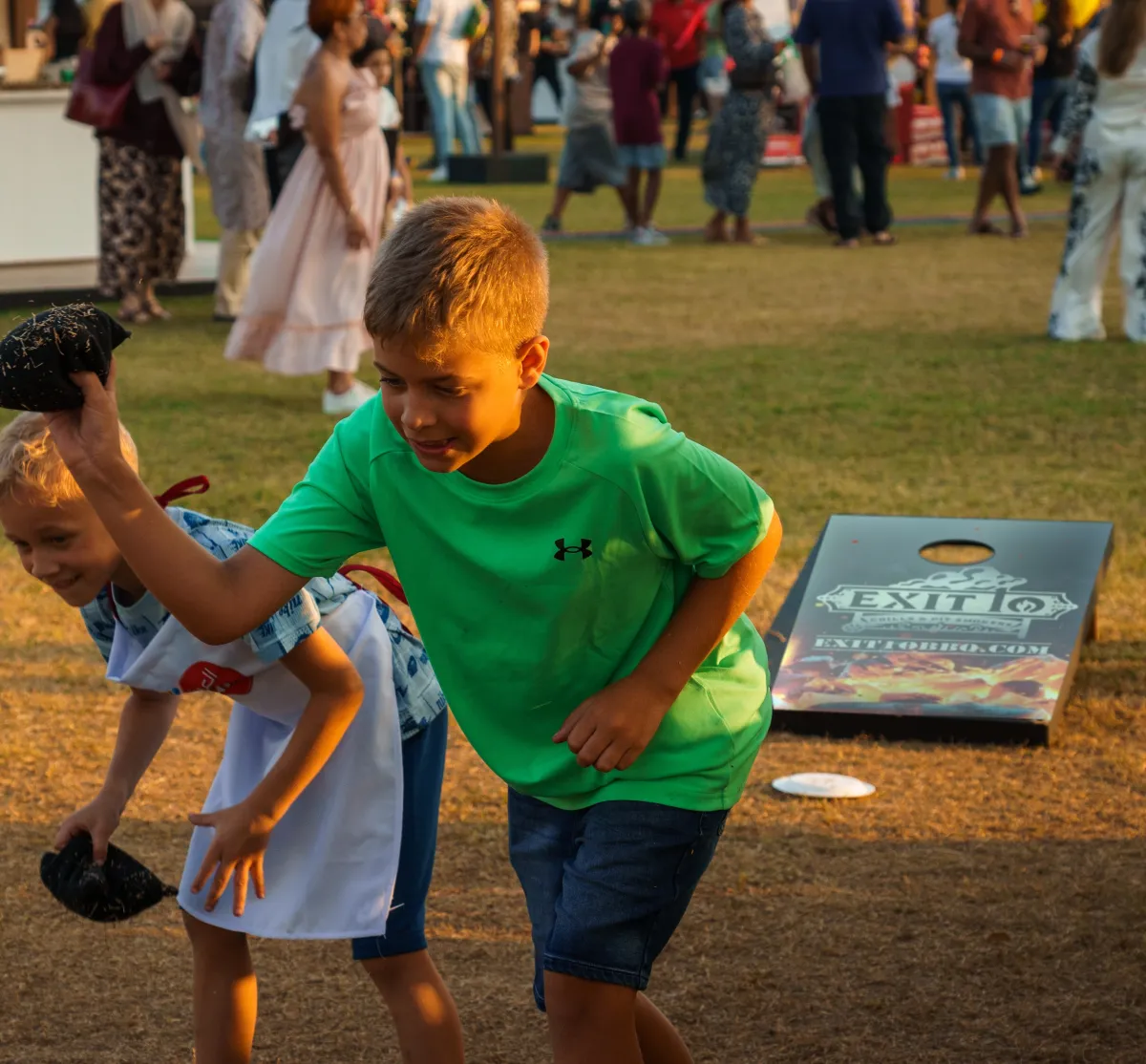 Kids playing cornhole on the Exit 10 board at Taste of Abu Dhabi 2024